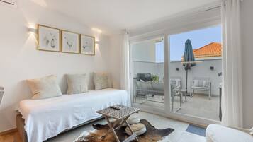 Une chambre à coucher avec un lit, une petite table et un tapis en peau de vache.