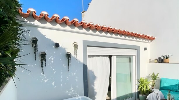 A hot tub, a sliding glass door, and a white wall with a tiled roof. - Casa Lusitano With Jacuzzi by Valada Village (Valada)