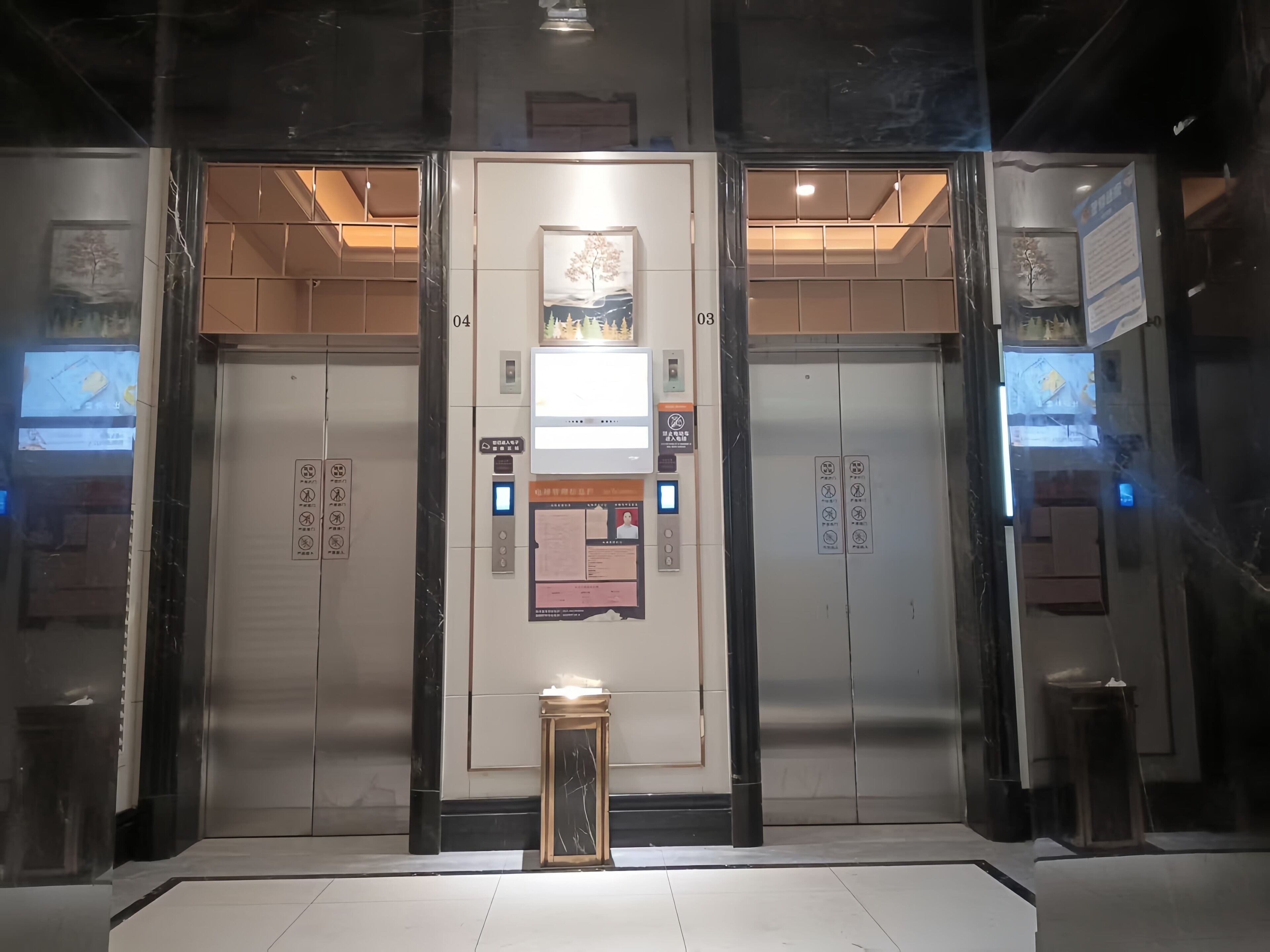 A modern elevator with digital displays, emergency instructions, and a small table with a light.