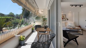 A balcony with a table, chairs, and potted plants. - Studio Apartment 'Athens-riviera in Front' with Sea View, Wi-Fi and Air Conditioning (Voula)
