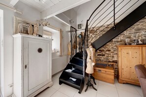 A room with a staircase, a mannequin, a wooden cabinet, and a white wardrobe. - Maisonette Ti Arzou – 300m from the Beach (Le Conquet)