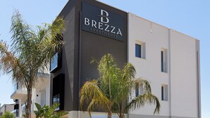 A modern apartment building with a dark facade and a sign reading 'BREZZA APARTMENTS.' - Etesia Apartment with Balcony, Wi-Fi and Air Conditioning (Santa Flavia)