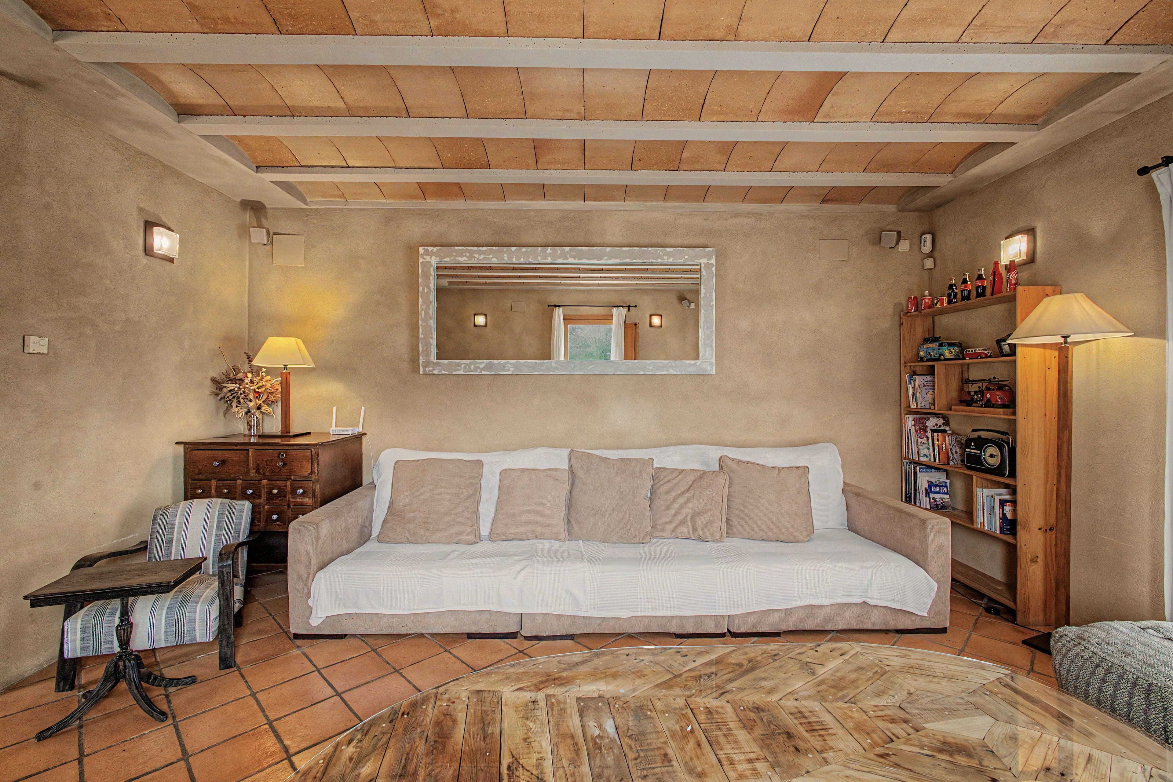 Una sala de estar acogedora con sofá, mesa de centro, estantería y chimenea.