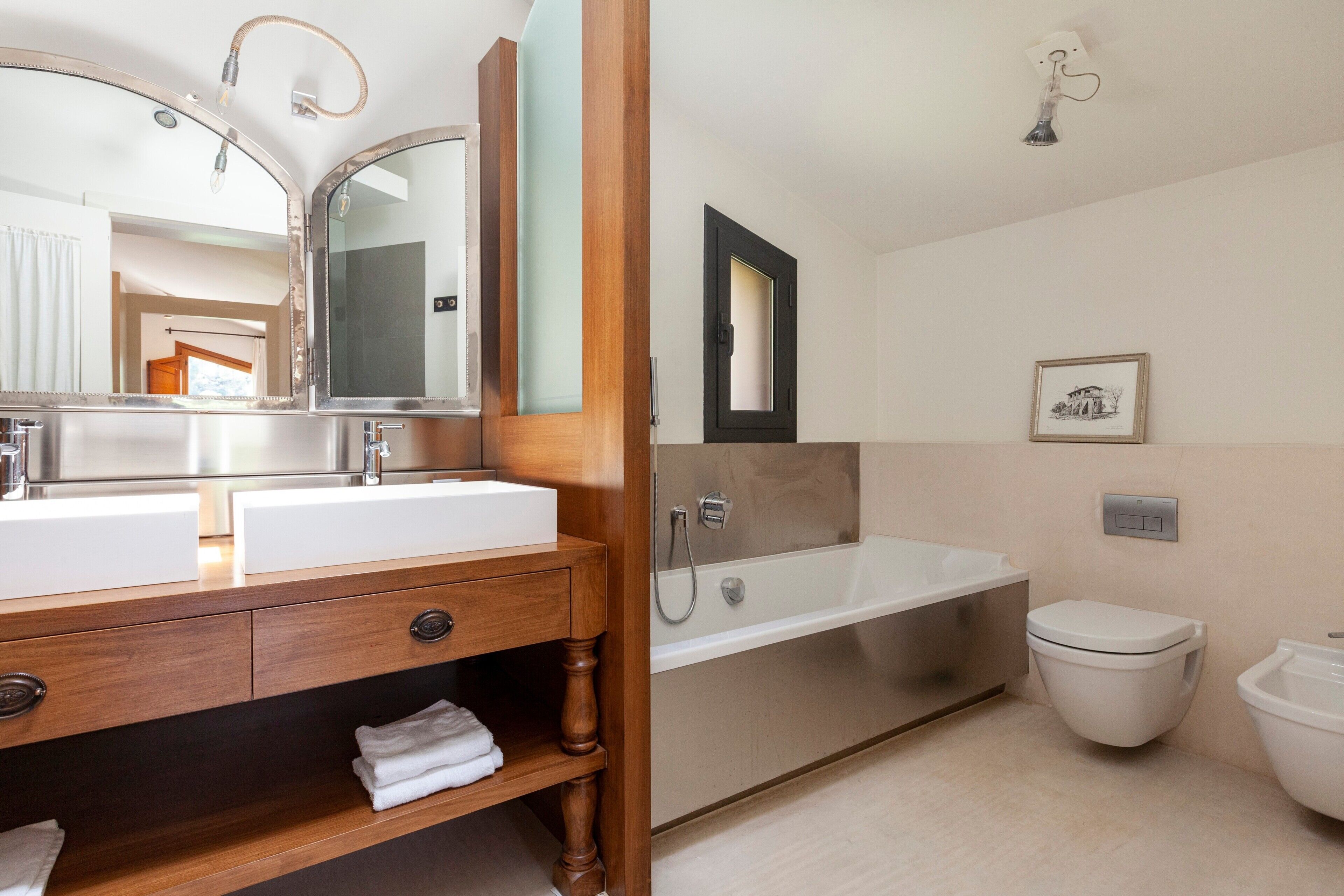 Un baño con lavamanos doble, bañera, inodoro y ducha.