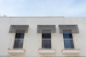 A building with three windows, each with a balcony and a mesh covering. - "Casetta Azzurromare" Room 'Primavera' with Sea View, Wi-Fi and Air Conditioning (San Vito Lo Capo)