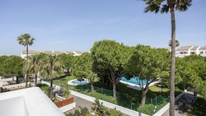 Ein Resort mit mehreren Gebäuden, einem Schwimmbad und üppiger Vegetation.
