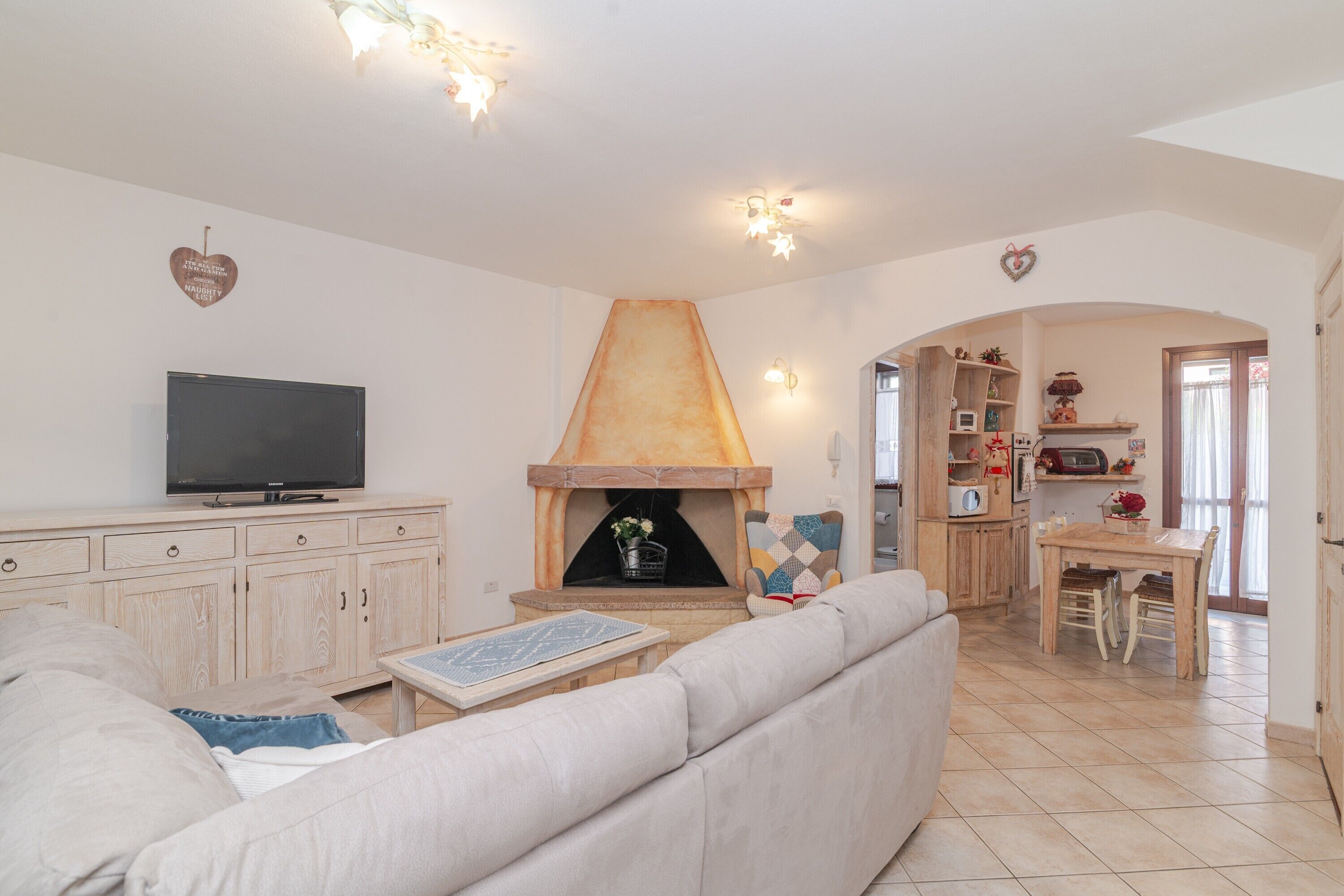 Ein Wohnzimmer mit einer Couch, Fernseher, Kamin und einem Essbereich mit Tisch und Stühlen.