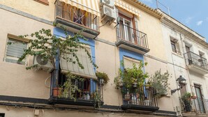 A building with a balcony, a door, and a window.
