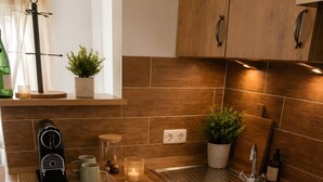 Una cucina con mobili in legno, forno integrato, lavello in acciaio inossidabile e macchina per il caffè.