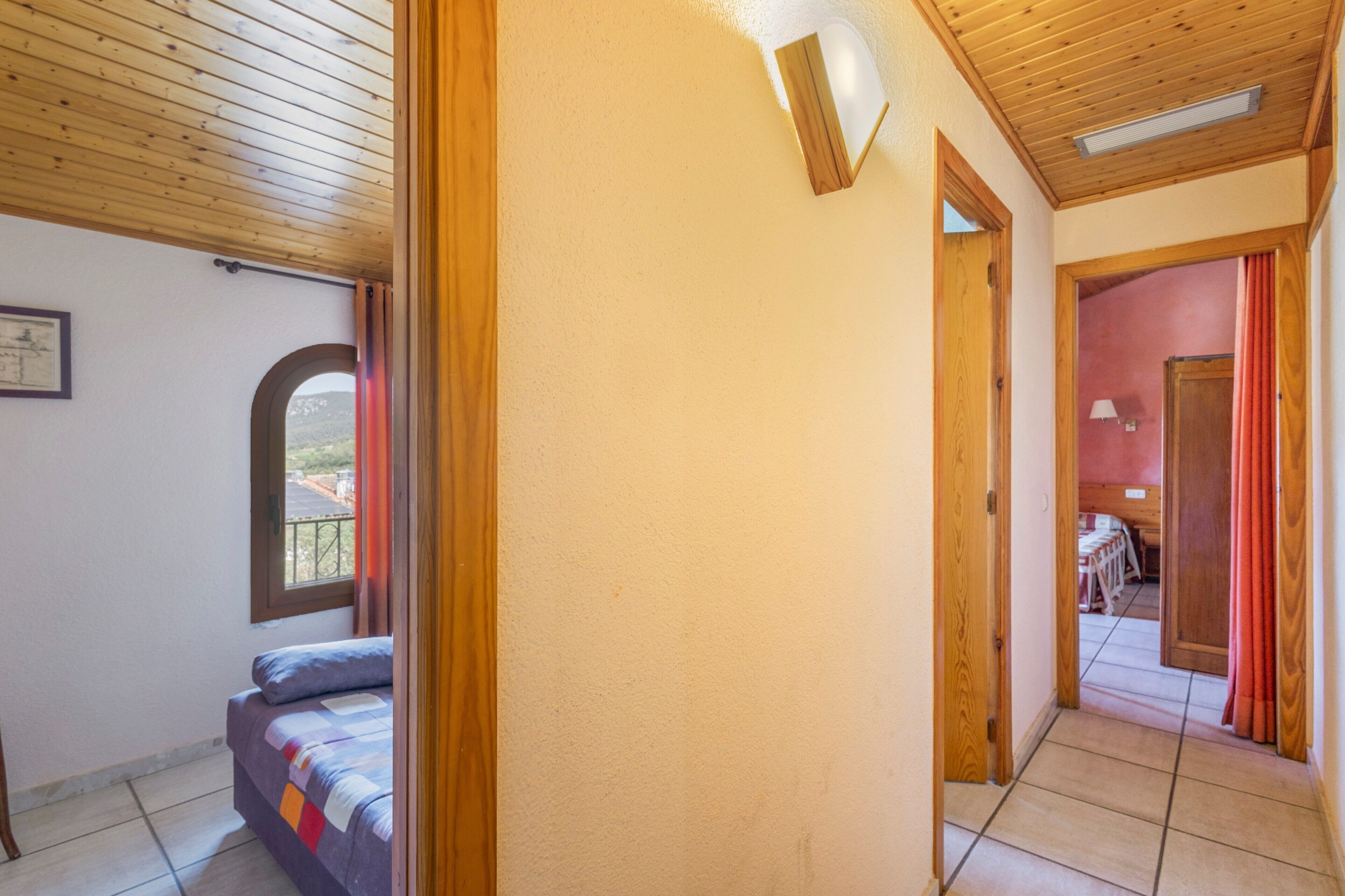 Una camera da letto con un letto, una finestra e una porta che dà su un'altra stanza.