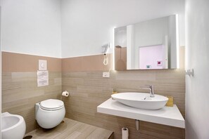 A modern bathroom with a toilet, bidet, and sink. - Le Stanze In Centro – Triple Room (Naples)