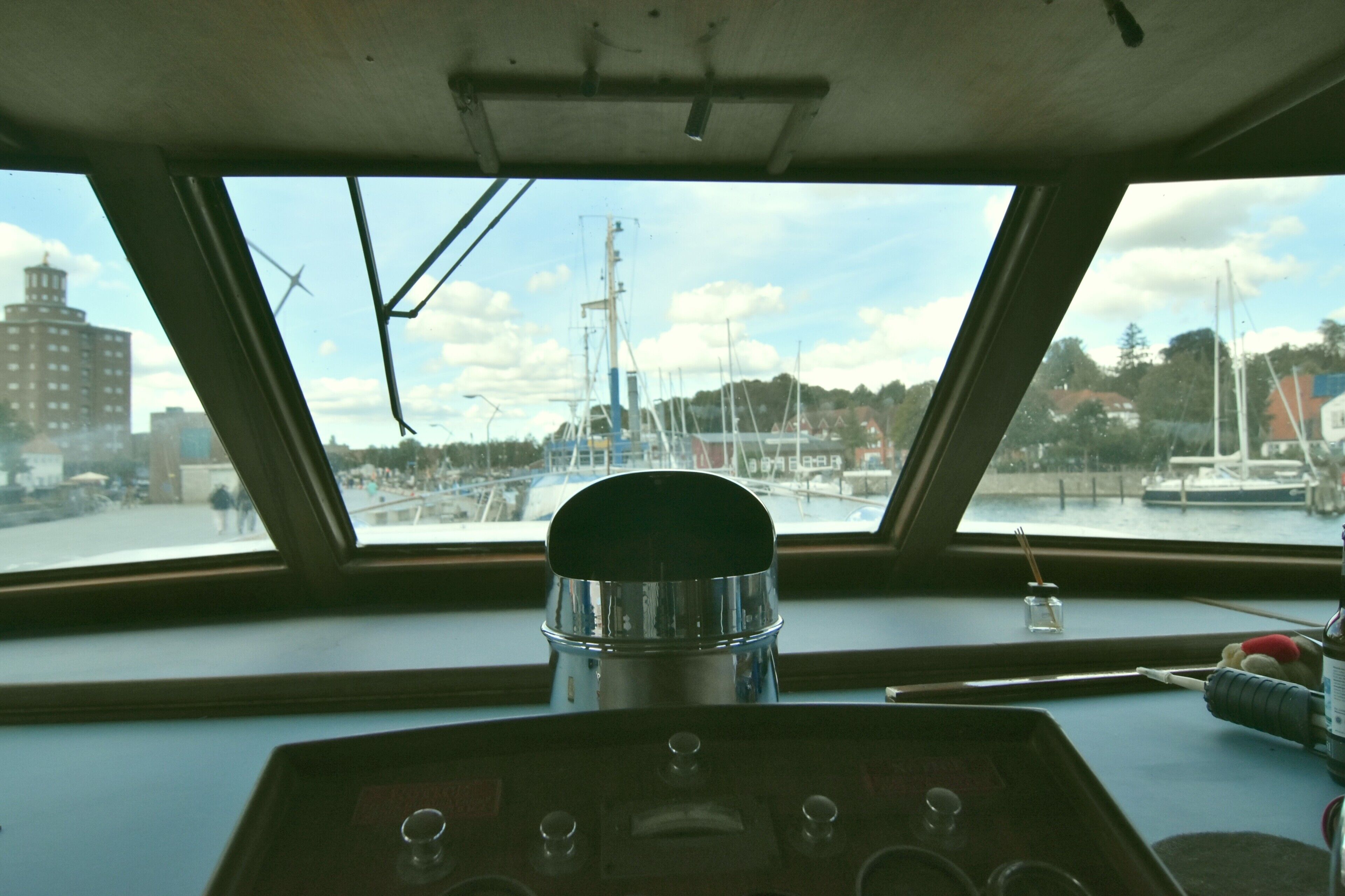 A control panel with a view of a marina through a window.
