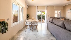 Een modern interieur met een eethoek, een bank en een plafondventilator.