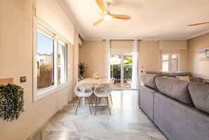 Ein modernes Interieur mit Essbereich, einer Couch und einem Deckenventilator.