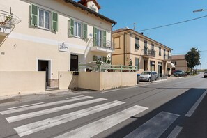 A street view with buildings, a crosswalk, and parked cars. - Room 'Pesci' with Mountain View, Wi-Fi and Air Conditioning (Bastia)