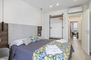 Ein modernes Hotelzimmer mit einem großen Bett, einem Hängesessel und Blick auf die Stadt.