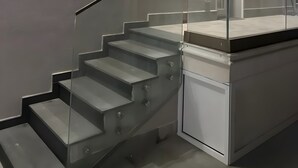 A modern staircase with glass railings, a small window, and built-in lighting. - Villa 'Zefira Mare' with Sea View, Wi-Fi, and Air Conditioning (Altavilla Milicia)