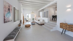 Een moderne woonkamer met een bank, een slaapbank en een eethoek.