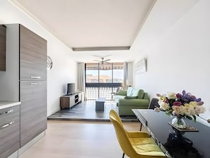 Un appartement moderne doté d’un coin repas, d’une cuisine et d’un balcon avec vue.