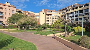 Un ensemble résidentiel comprenant plusieurs immeubles d’appartements, un espace central pavé et des espaces verts environnants.