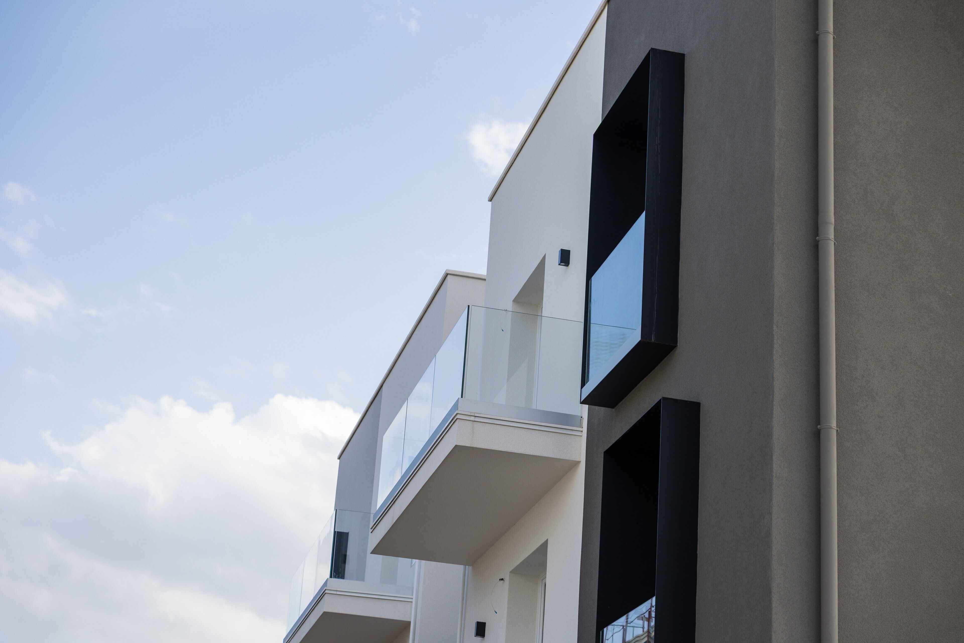 Een modern gebouw met balkons en grote ramen.