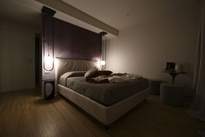 A bedroom with a bed, bedside lamps, a nightstand, and a small table with a lamp. - COBALTO Room- Aurisea Luxury Stays (Bari)
