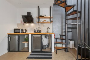 Cozinha compacta com micro-ondas, chaleira e cafeteira.