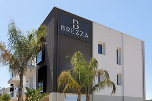 A modern apartment building with a dark facade and a sign reading 'BREZZA APARTMENTS.' - 'Bora' Apartment with Balcony, Wi-Fi and Air Conditioning (Santa Flavia)