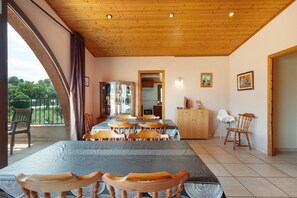 Un comedor con una gran mesa, sillas, un armario y vistas al exterior.