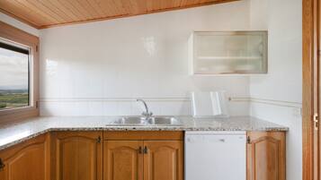 Una cucina con mobili in legno, un'lavastoviglie bianca e una finestra vista.