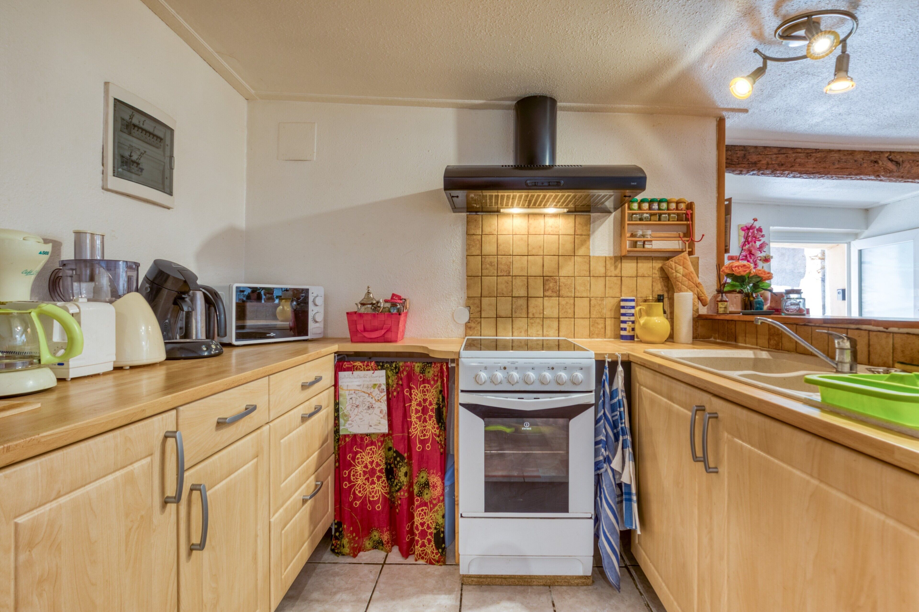 A kitchen with wooden cabinets, a stove, a sink, and a tiled backsplash.