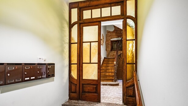 A staircase with wooden steps and a wooden door leading to another room.