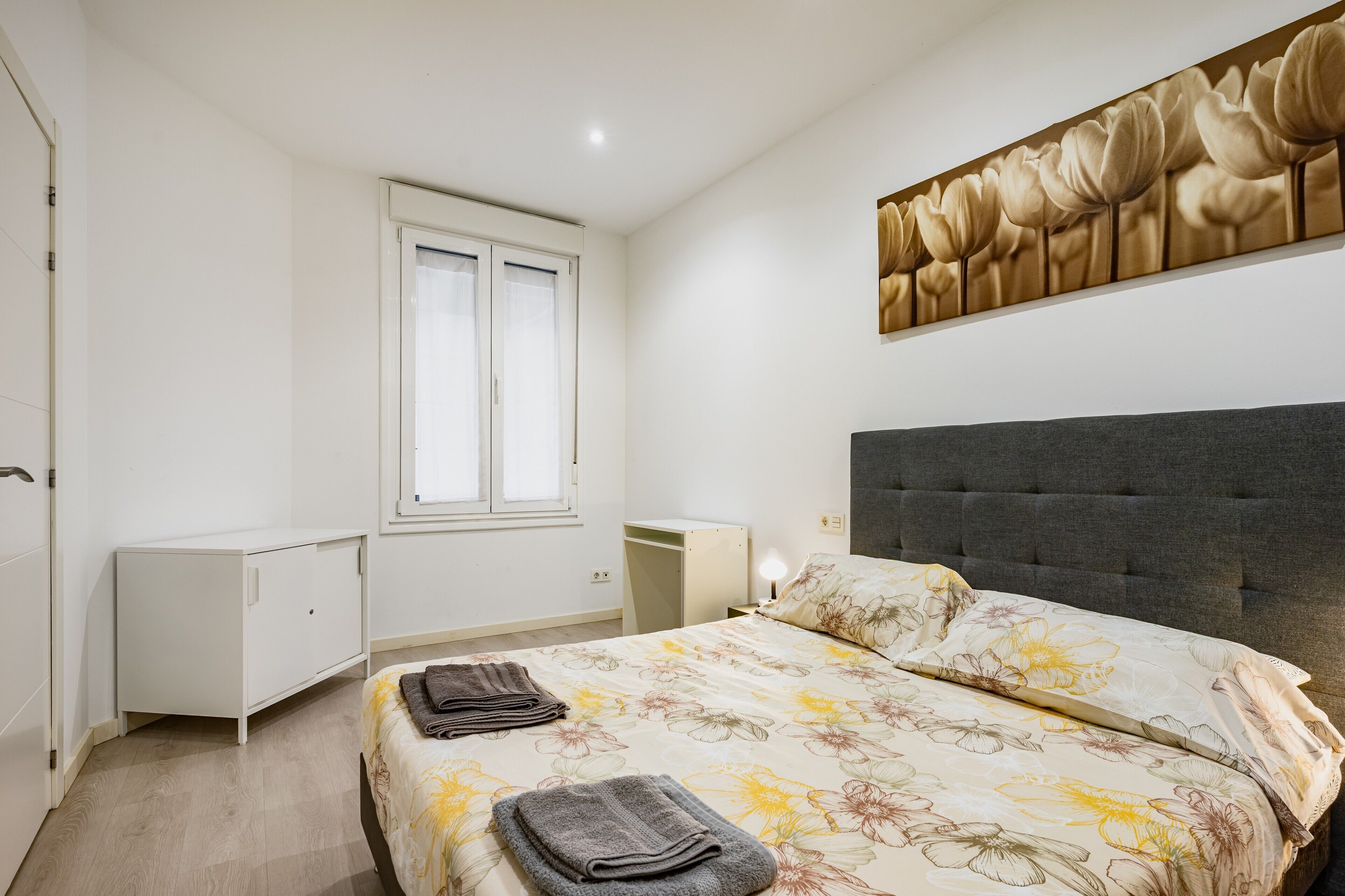 Un dormitorio con una cama, un escritorio, un armario y una ventana.