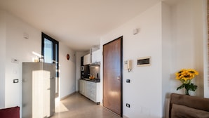 Eine moderne Küche mit Kühlschrank, Mikrowelle und Herd. Ein Essbereich mit Tisch und Stühlen ist ebenfalls vorhanden.