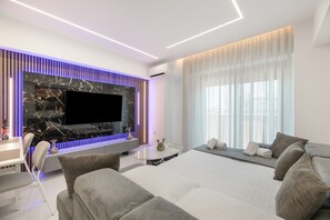 Ein modernes Wohnzimmer mit Flachbildfernseher, einer Wand mit Marmorverkleidung, einer Couch und einem Essbereich.