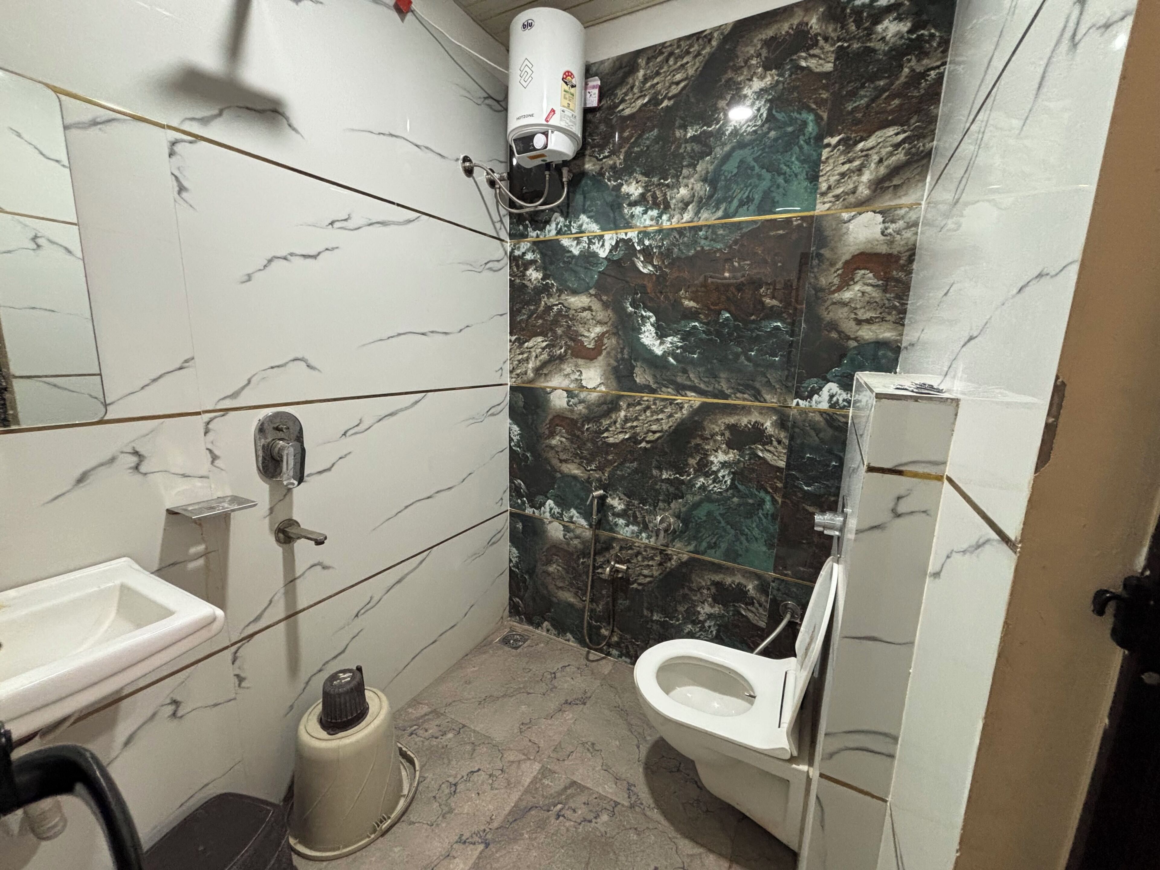 A bathroom with a toilet, sink, and shower.