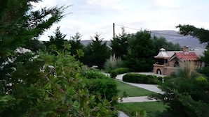 Una casa con tetto in tegole rosse, immersa nel verde e con un vialetto sinuoso.