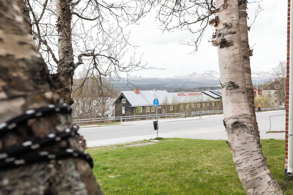 Un hotel amb un cartell que diu 'HOTELL FUNASDALEN' i un senyal blau de direcció.