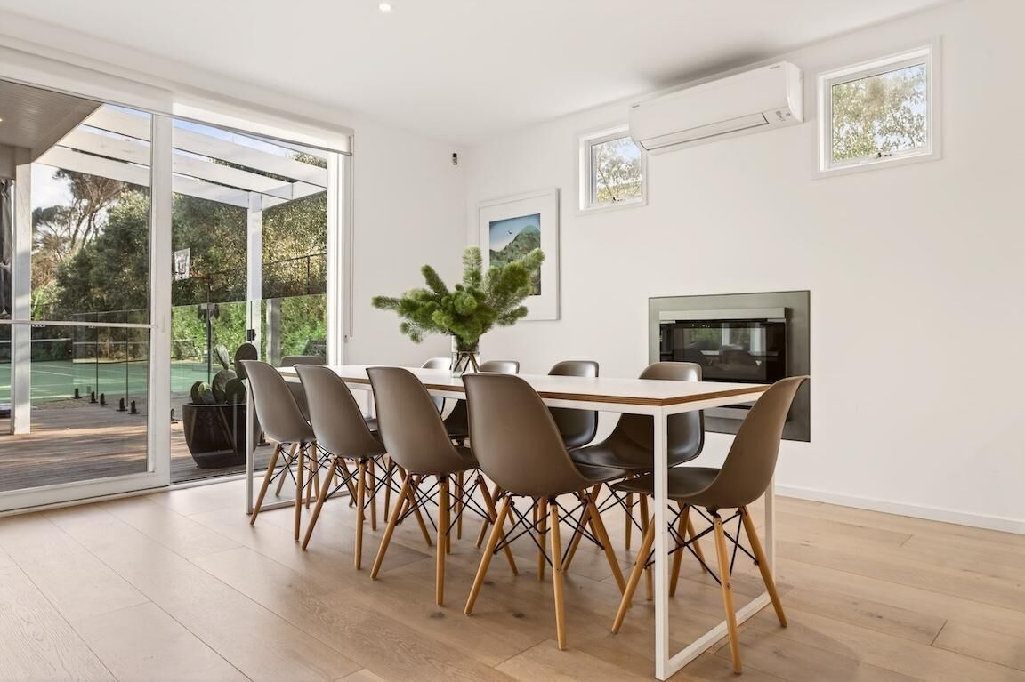 Un espace repas moderne comprenant une grande table, des chaises et un téléviseur.