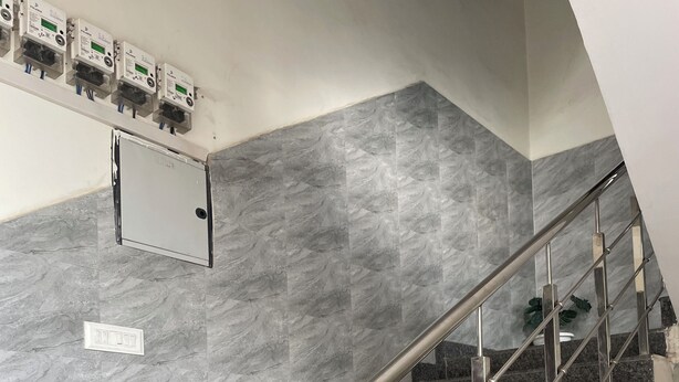 A modern staircase with metal railings, marble walls, and electrical outlets. - Slate Majestic 1BHKs Sector 53 Noida (Noida)
