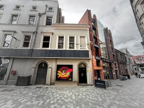 A building with a large, colorful mural on the front, a sign reading 'Wetherspoon,' and a brick facade. - Yellow Submarine Apartments - Sleeps 19 (Liverpool)