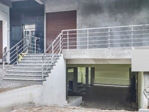 A staircase leading to a covered area with a metal railing, concrete steps, and a partially visible door. - Super Collection O Rbs Kothapet-nagole Road (Hyderabad)