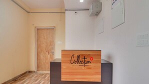 Een hotel receptiebalie met een houten paneel waarop 'Collection' en 'Signature Stays by DVG' staan.