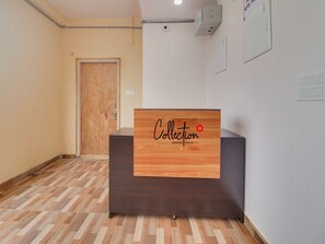 A hotel reception desk with a wooden panel displaying 'Collection' and 'Signature Stays by DVG.' - Super Collection O Rbs Kothapet-nagole Road (Hyderabad)