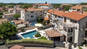 A residential area with stone buildings, a swimming pool, and a gated entrance. - Holiday house with pool for 10 persons, 2 separate accommodation units,in Porec (Dračevac)