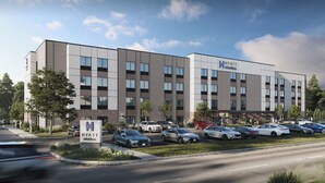 A modern hotel building with a parking lot.