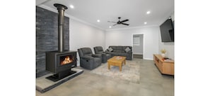 Una sala de estar moderna con chimenea, dos sofás grises, una mesa de centro y un televisor.
