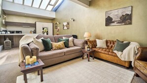 A spacious living area with a high ceiling, a skylight, a sofa set, a coffee table, and a painting on the wall. - York City Centre | Shambles & Minster Walk (York)