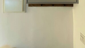 A room with a large whiteboard, a white air conditioning unit, and a wooden shelf. - Urban Penthouse Loft W Jacuzzi (Haifa)