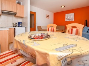 A compact room with a dining table, chairs, a kitchen area, and a bed. - Apartments Aurel Suites (Rogoznica)